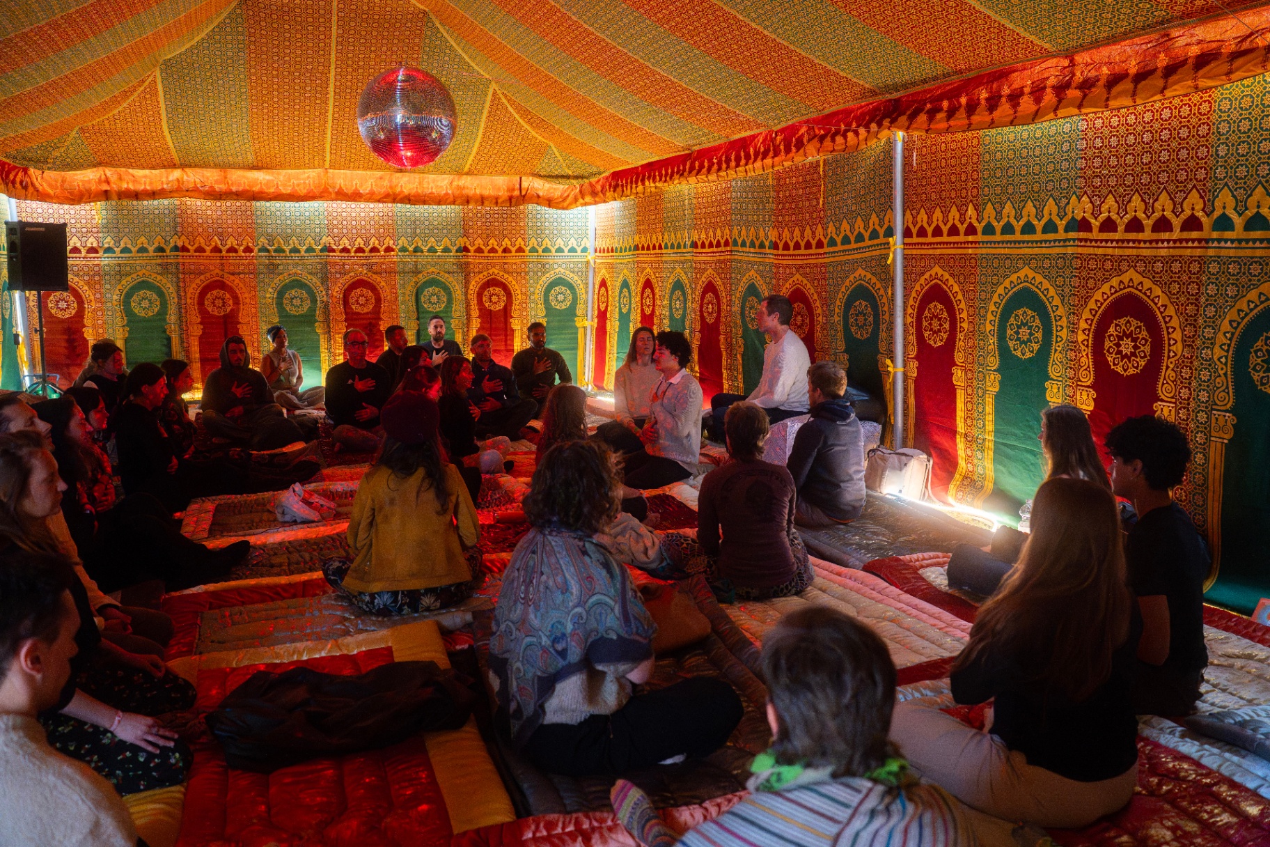 A group gathered inside a patterned tent
