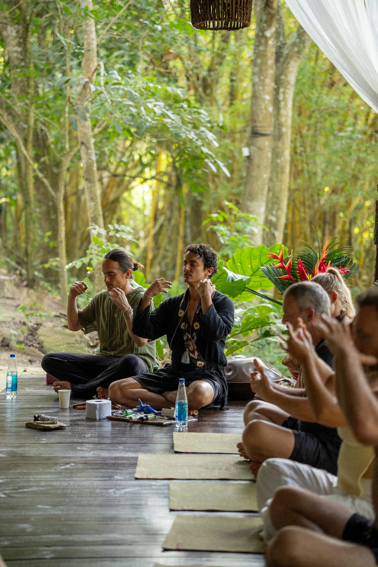 Facilitators seated in a forest circle